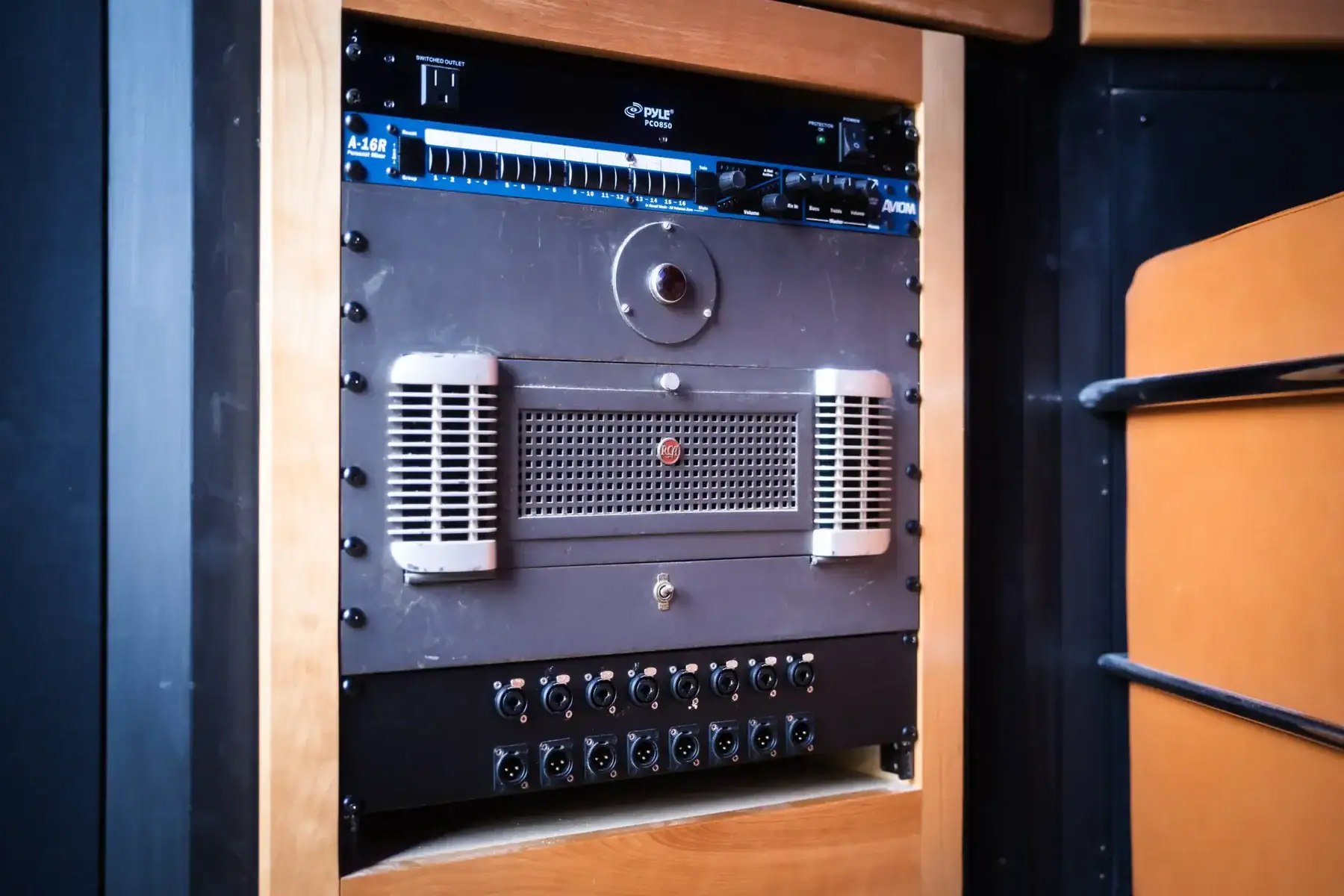Audio equipment rack featuring an amplifier, mixer, and various input connections.