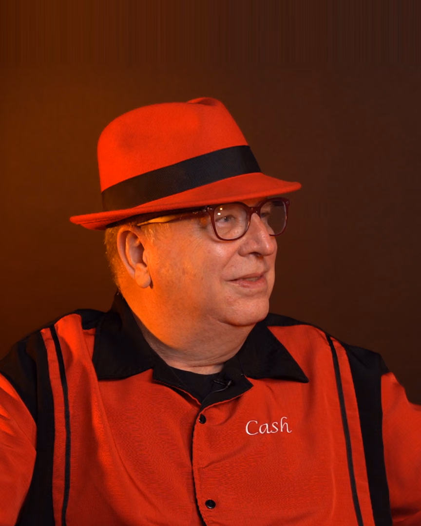 Christopher Cash, founder of Sonic-Rocket Productions, in a red fedora and red studio shirt