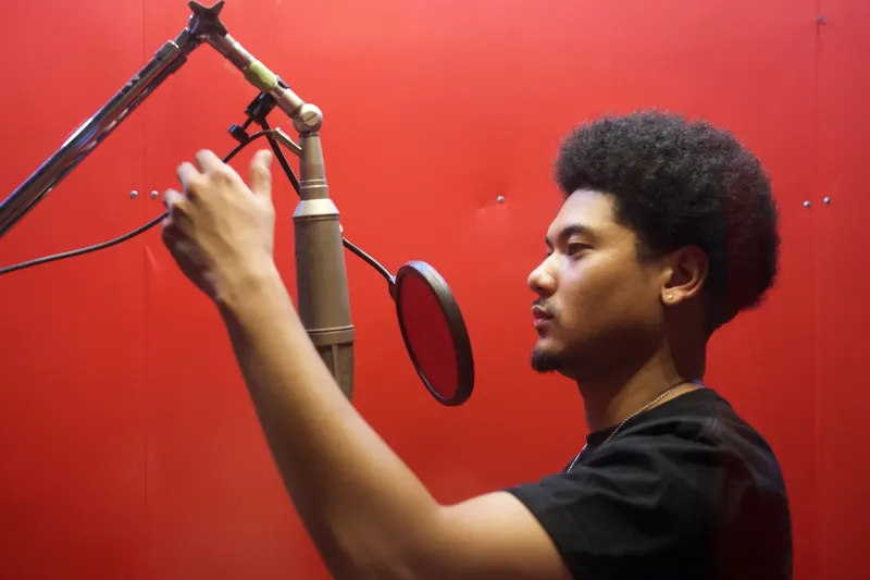 Kai McGilvery setting a vocal microphone in the booth