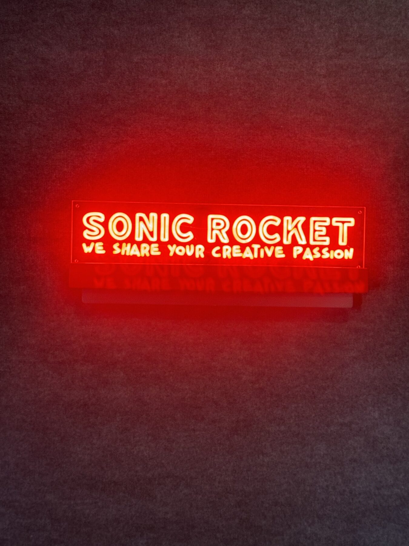Red neon Sonic Rocket sign: We share your creative passion