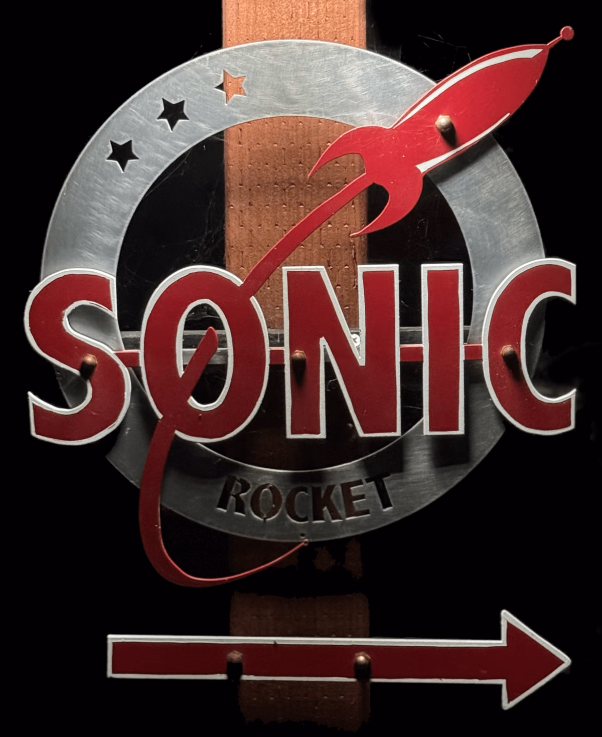 Sonic-Rocket metal sign with a red rocket and arrow outside the studio